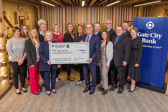 Gate City Bank team members stand with YWCA Cass Clay representatives & hold a big check for affordable housing worth $560K