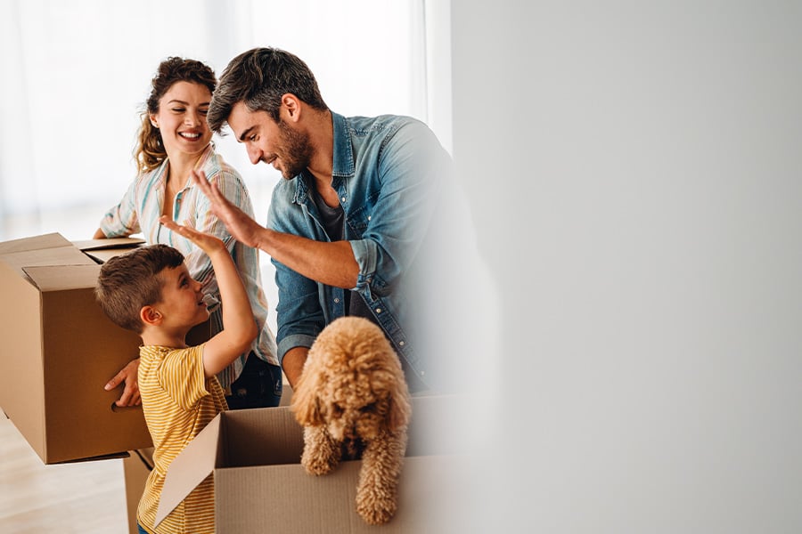 Father gives son a high-five while unpacking boxes in their new home after opening checking accounts at Gate City Bank
