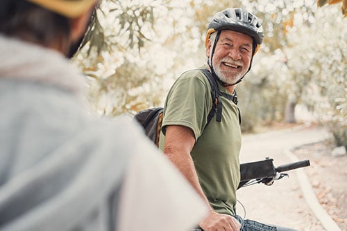 smiling senior gentleman wearing a bike helmet, heading to his nearest Gate City Bank location