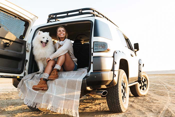 young woman with her Samoyed dog in the back of a Jeep, purchased with a Gate City Bank auto loan