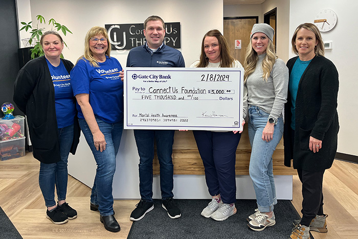 Gate City Bank team members surprise ConnectUs Foundation staffers with a big check written out for $5,000 in Williston, ND
