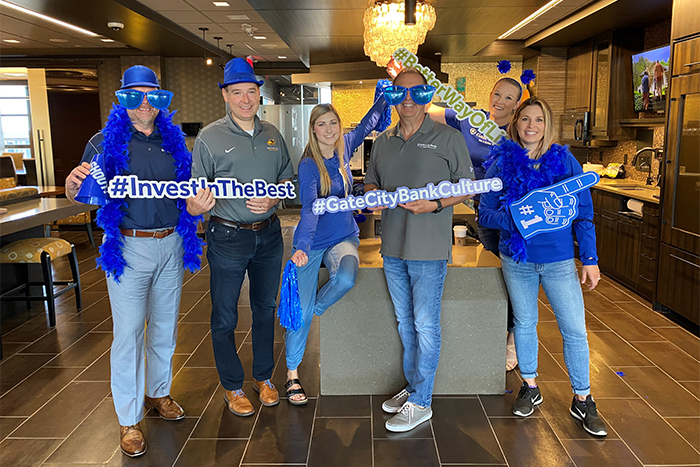 team members sporting goofy props pose for a photo while celebrating their culture