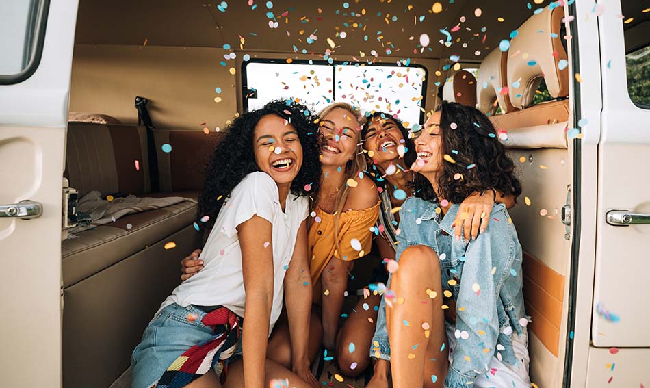 four happy friends surrounded by confetti, celebrating Gate City Bank’s 100th anniversary