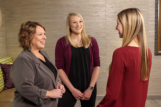 three women talk with one another and enjoy their careers at Gate City Bank