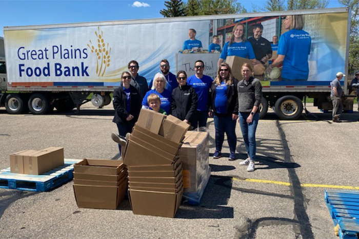 Minot Gate City Bank volunteers take photo in front of Great Plains Food Bank truck