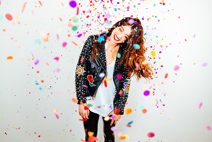 Happy young lady laughs amid pieces of confetti to celebrate Gate City Bank’s 100 years of better banking