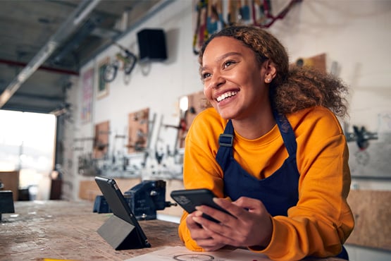 a happy cash management business customer looks up from her phone