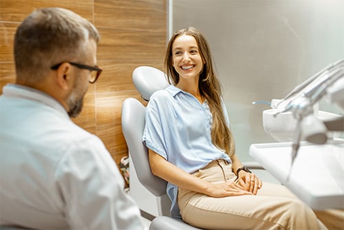 dentist visits with a smiling young female patient 