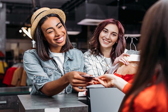 Smiling young women shop with their Gate City Bank debit card.