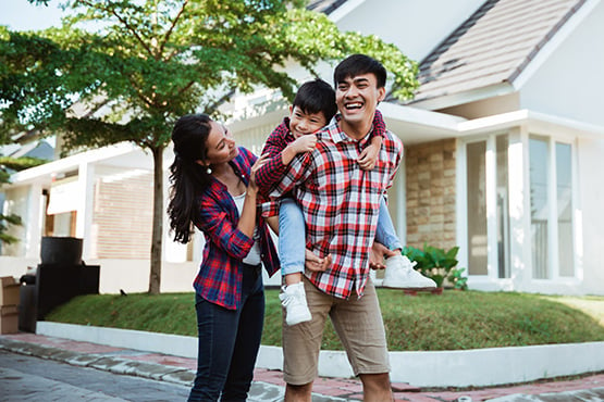 happy young parents and son stand outside after cash out refinancing for a project