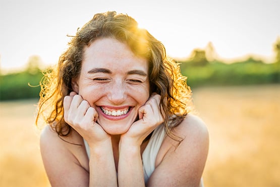 Curly-haired woman with a big smile in Fargo, ND, who just made the switch to Gate City Bank with new checking account offers