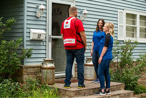 American Red Cross volunteer and two Gate City Bank team members discuss smoke alarm safety outside a home in Fargo, ND