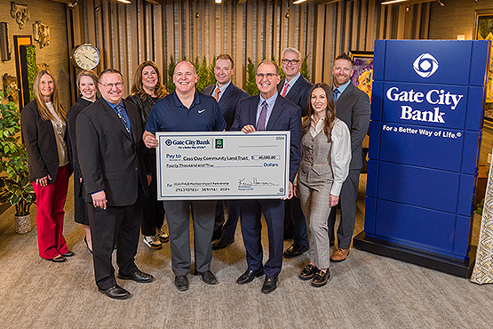 Gate City Bank team members pose with a Cass Clay Community Land Trust rep holding a big $40K check for affordable housing