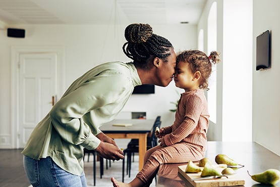 mother and child happily snuggle faces after moving into their new home financed by gate city bank