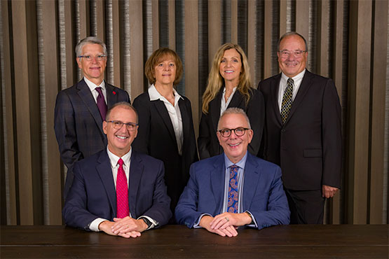 Gate City Bank's board members gather next to a conference room table and smile at the camera