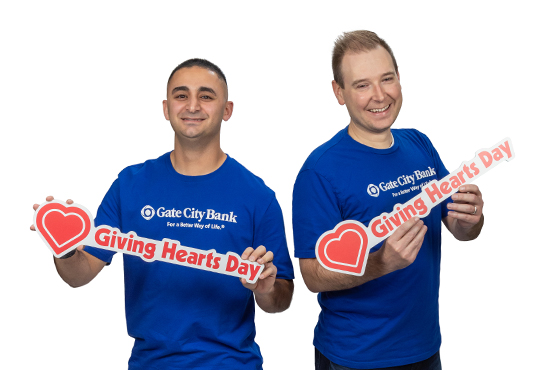 Gate City Bank team members hold Giving Hearts Day signs and smile for a good cause