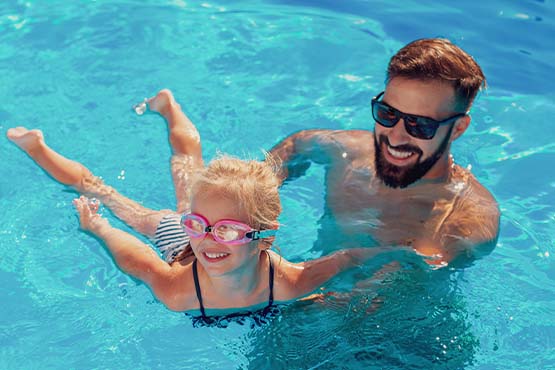 father and daughter swim in new pool they obtained with a home equity line of credit
