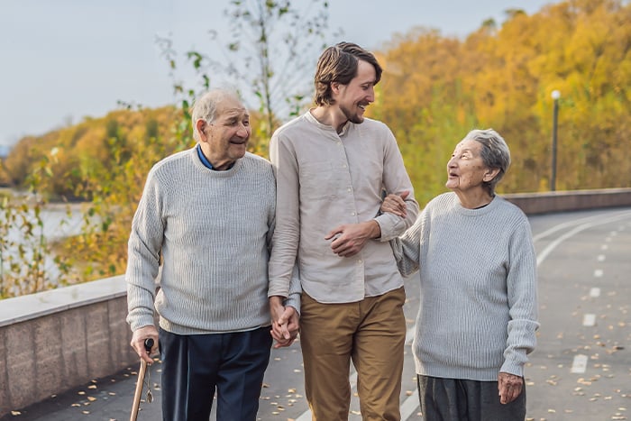 Young man escorts a smiling senior couple on a walk on a beautiful autumn day in North Dakota