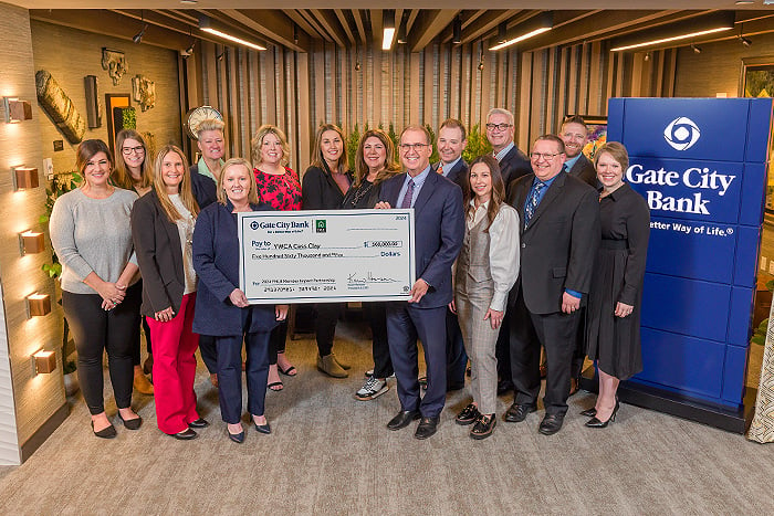 Gate City Bank team members pose with YWCA Cass Clay representatives holding a big check for affordable housing worth $560K