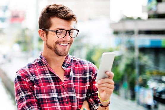 guy in glasses and purple shirt enjoys great savings account rates on phone