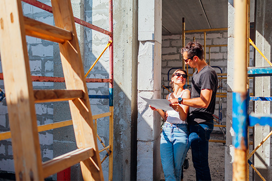 Young couple reviews blueprints after securing financing for their new build in Fargo, ND, with Gate City Bank construction loans