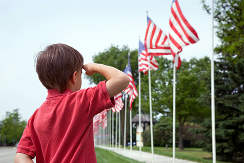 Young boy salutes the American flag