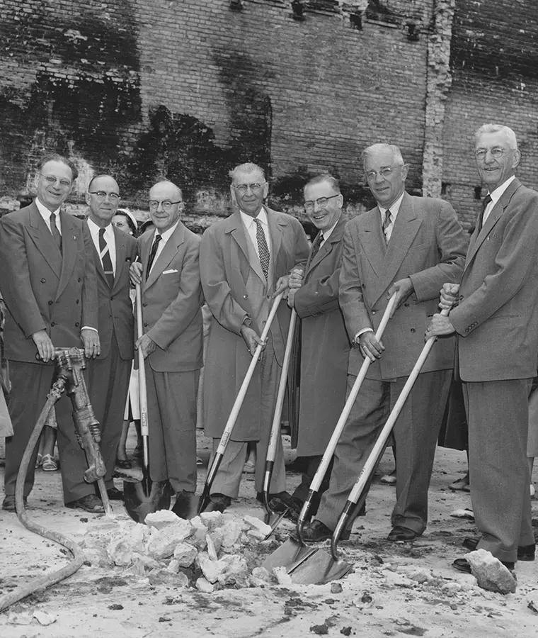 1960s black and white photo of seven Gate City Bank leaders and associates breaking ground at a new site