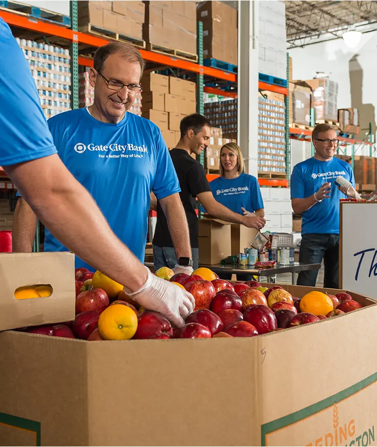 2010s color photo of president and CEO Kevin Hanson volunteering at food pantry with fellow team members