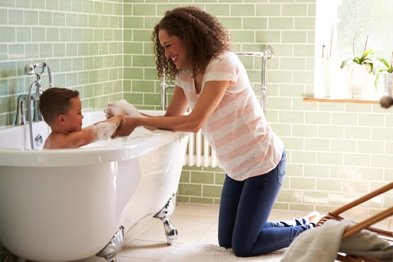 adoring mom giving her son a bubble bath in a new clawfoot tub, thanks to a home equity loan from Gate City Bank in ND